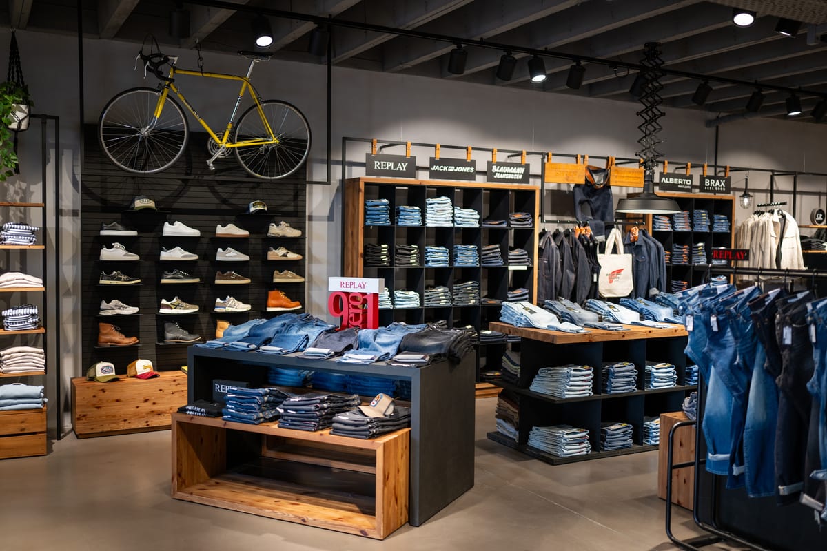 Denimbereich mit Jeansregalen und einem Rennrad an der Wand